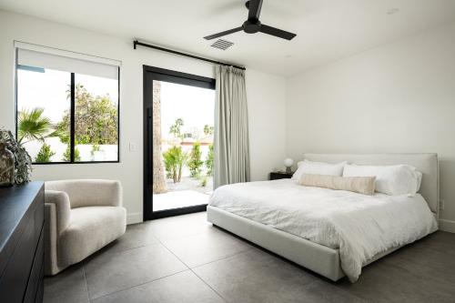 a white bedroom with a bed and a chair at The MYAH by Porter NEWLY REMODELED Enjoy the Pool Firepit Luxury in Phoenix