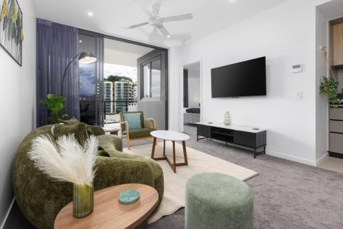 a living room with a couch and chairs and a tv at West End 2BR Gem with Rooftop Pool, Balcony & Parking in Brisbane