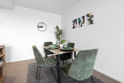 a dining room with a table and chairs at West End 2BR Gem with Rooftop Pool, Balcony & Parking in Brisbane
