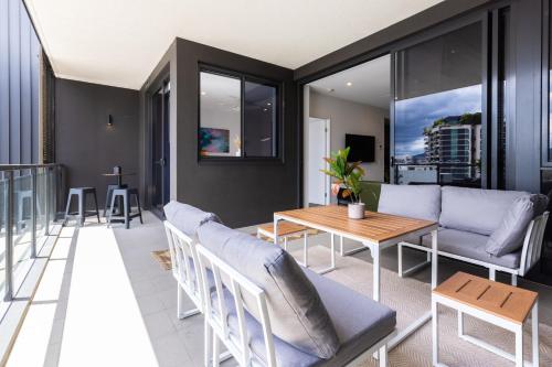 a living room with a couch and a table at West End 2BR Gem with Rooftop Pool, Balcony & Parking in Brisbane