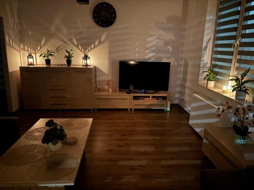 een woonkamer met een flatscreen-tv en een tafel bij Apartament w Centrum Malborka in Malbork