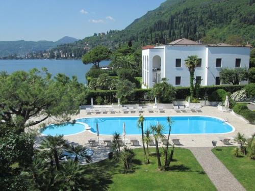 サロにあるHotel Spiaggia d'Oro - Charme & Boutique - Garda Lake Collectionのスイミングプールと湖付きのヴィラ