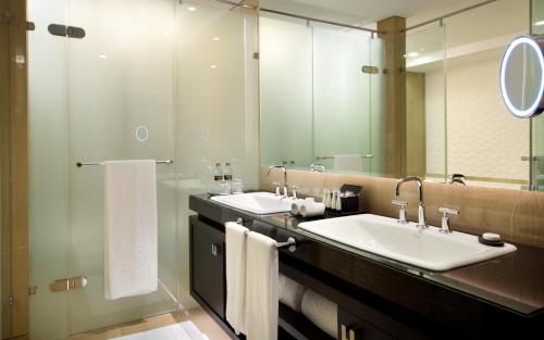 a bathroom with two sinks and a large mirror at Sofitel Abu Dhabi Corniche in Abu Dhabi