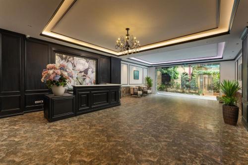 a large hall with a chandelier and flowers on the walls at Grand Vĩnh Tuy Hanoi Hotel&Spa in Mai Phúc