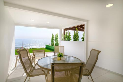 a dining room with a table and chairs at Wavestone Beachfront House in Meneou