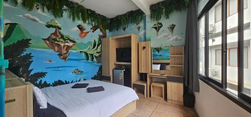 ein Schlafzimmer mit einem Bett und einem Gemälde an der Wand in der Unterkunft Urban Jungle Social in Bangkok