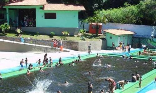 un grupo de personas en una piscina en un parque acuático en Recanto dos Pássaros Olivença, en Ilhéus
