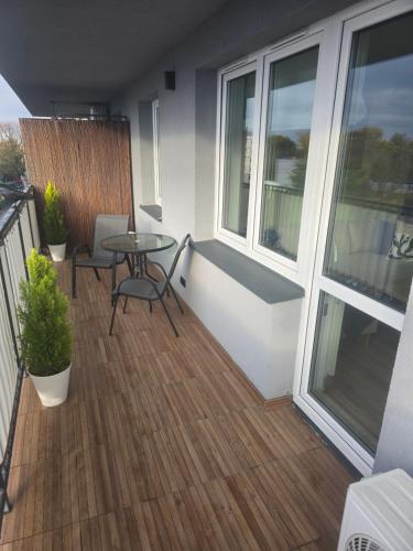 un balcone con tavolo e sedie e una finestra di Apartament Ami a Płock