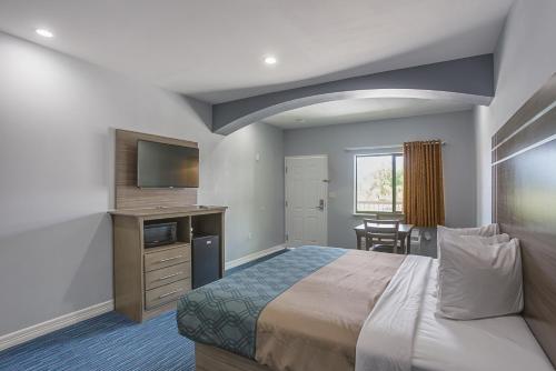 um quarto de hotel com uma cama e uma televisão em Home Place Inn Spring I-45 North and 1960 em Westfield