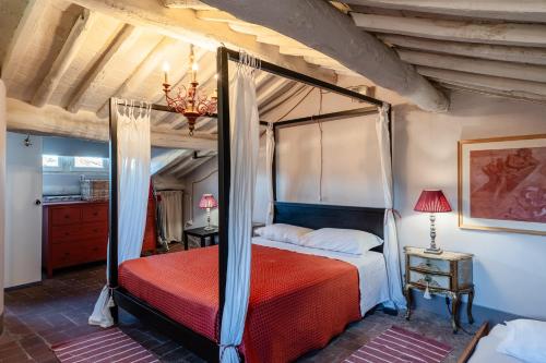 a bedroom with a canopy bed with a red comforter at Il Mazzocchio - Lucca Centro in Lucca
