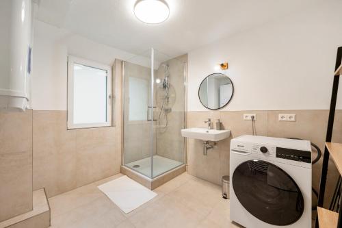 a washing machine in a bathroom with a sink at CharmÖHR Homes in Öhringen