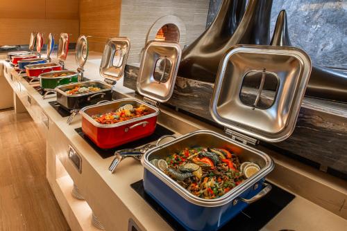 un buffet con muchas bandejas de comida en un mostrador en Braira Jazan Hotel, en Jazan