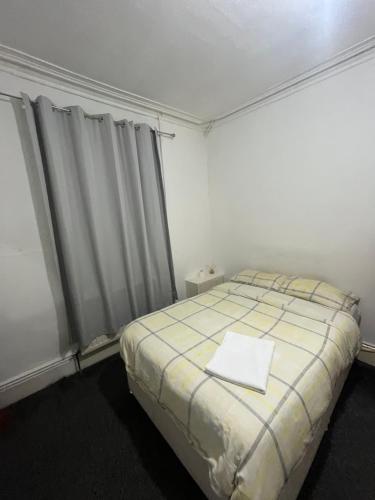 a bedroom with a bed with a yellow and white blanket at Cooperate home2 in Oldham