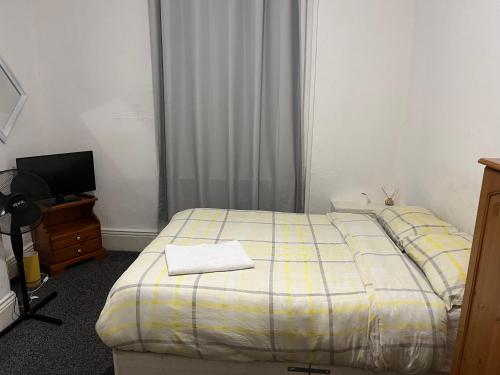 オールダムにあるCooperate home2のベッドとテレビのある小さな寝室