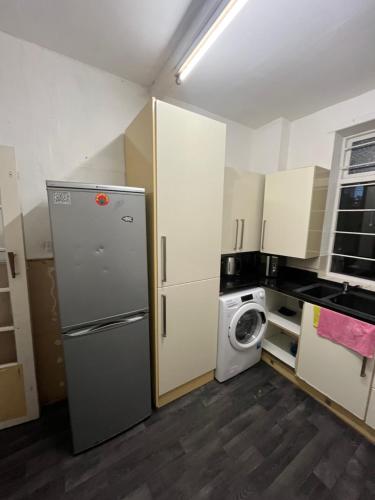 a kitchen with a refrigerator and a washing machine at Cooperate home2 in Oldham