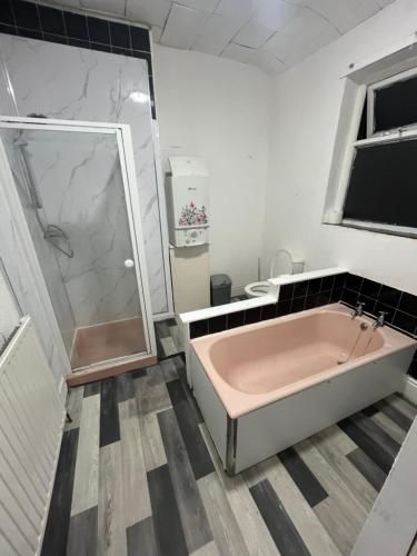 オールダムにあるCooperate home2のバスルーム(ピンクのバスタブ、シャワー付)