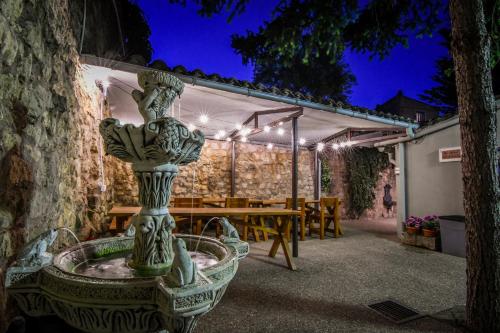 a stone fountain in front of a table with lights at La Cachava in Castrojeriz