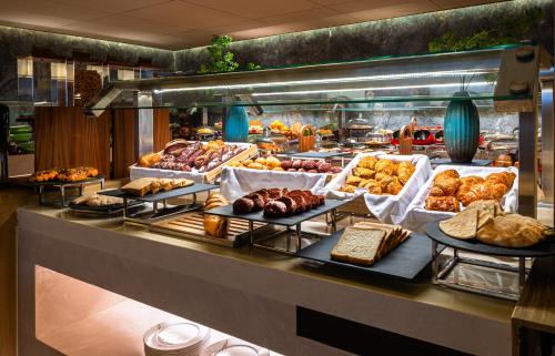 Una línea de buffet con diferentes tipos de pan y pasteles. en Braira Jazan Hotel, en Jazan