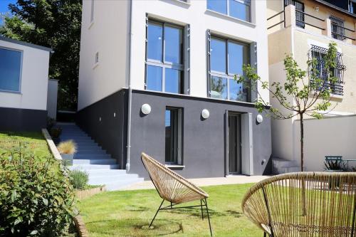 een huis met twee stoelen in de tuin bij Beautiful master villa in Fontenay-sous-Bois
