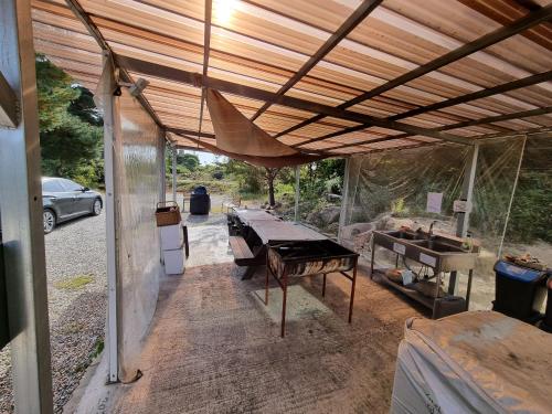 a covered patio with a table and a piano at 와바다펜션 속초고성 독채펜션12인 삼포해수욕장1분 바베큐불멍 in Goseong