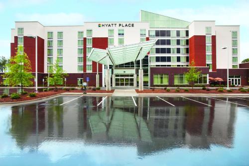 a building with a pool of water in front of it at Hyatt Place Raleigh Cary in Raleigh