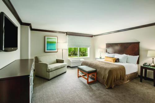 ローリーにあるHyatt Place Raleigh Caryのベッドと椅子のあるホテルの部屋
