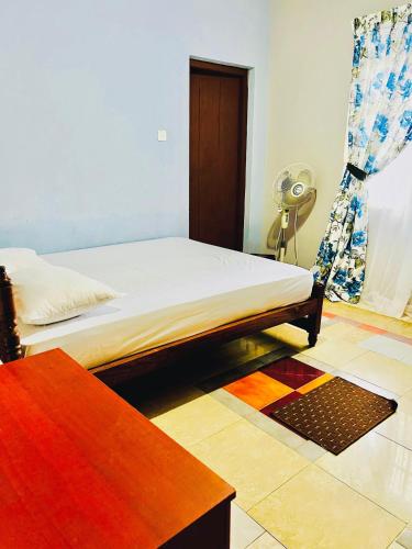 une chambre avec un lit et une table dedans dans l'établissement Lucky Holiday Bungalow, à Elkaduwa