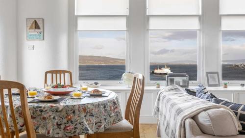 a dining room with a table and a view of the ocean at The Hidden Asset- Rothesay, Isle of Bute in Rothesay