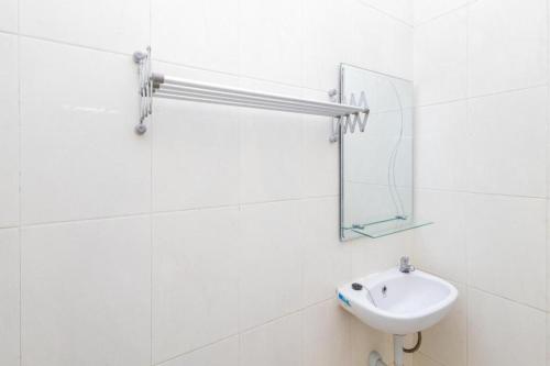 ein weißes Badezimmer mit Waschbecken und Spiegel in der Unterkunft RedDoorz near Wisata Museum Angkut 3 in Songgoriti