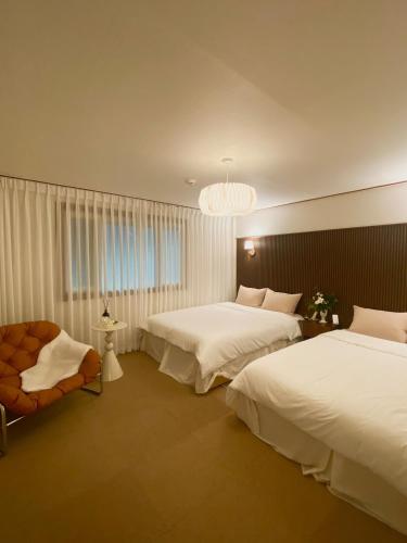 a hotel room with two beds and a chandelier at 넓고 편리한 숙소 in Pongsan-dong
