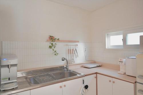 a kitchen with a sink and a microwave at 넓고 편리한 숙소 in Pongsan-dong