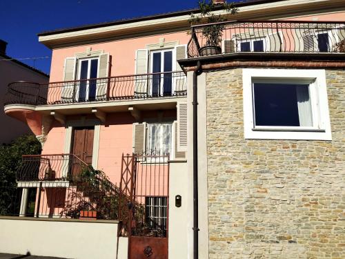 a pink building with a balcony on top of it at Casa Salvàn in Rodello