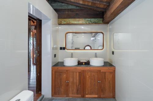a bathroom with two sinks and a mirror at Mandara villas ubud in Tegalalang