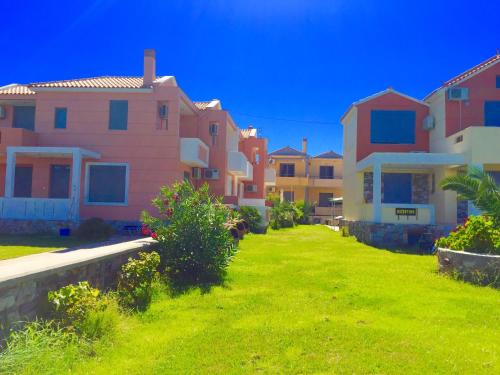 a row of houses on a green lawn at Nitelli's Houses in Skála Néon Kydonión