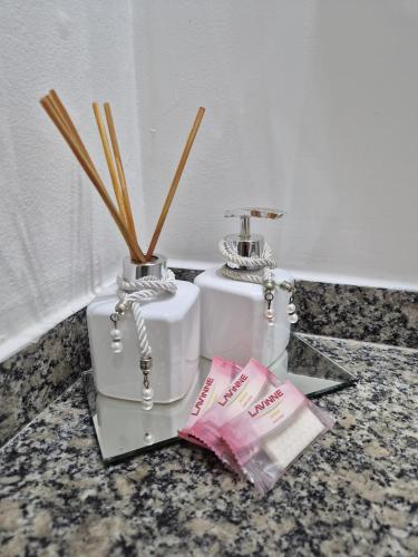 a counter with two bottles and a packet of toothpaste at Flat quarto e sala completo in Vitória