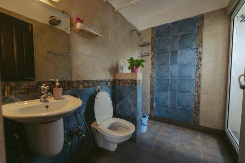 un baño con inodoro y lavabo en AQUAVISTA at CasaPhilomena, en Calangute