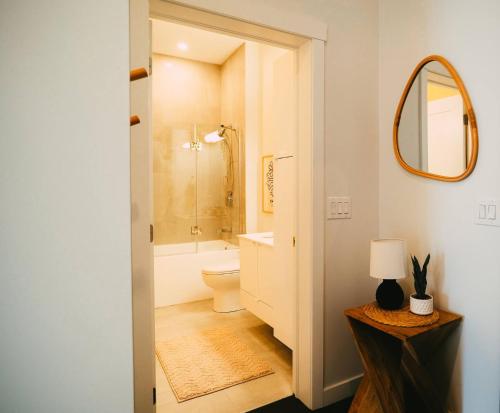 Un baño con inodoro, lavabo y espejo. en Cozy 2BR Penthouse Downtown - Parking Included, en Halifax