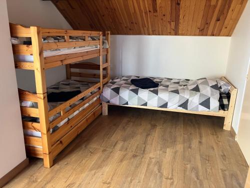 1 Schlafzimmer mit 2 Etagenbetten und einer Holzdecke in der Unterkunft La Lézardière - Chalet spacieux près des pistes in La Toussuire