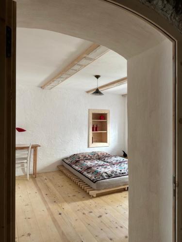 a bedroom with a bed in a white room at Historische Unterkunft Casa Tre Valli in Biasca