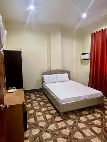 a bedroom with a bed and a red curtain at Feel Home Suites in Pagadian