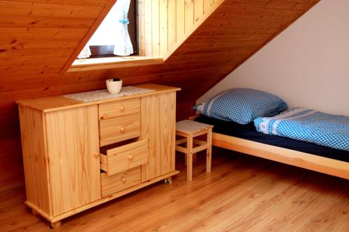 ein Schlafzimmer mit einem Bett und einer Kommode im Dachgeschoss in der Unterkunft Chata v Beskydech in Ostravice