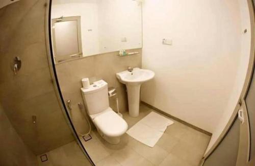 een badkamer met een toilet, een wastafel en een spiegel bij Riverside Hotel Colombo in Dandugama
