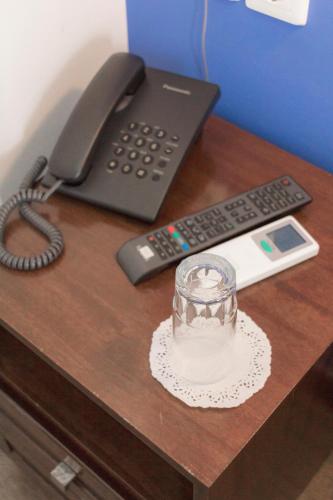 a desk with a phone and a candle and a glass at Athens Choice Hotel in Athens