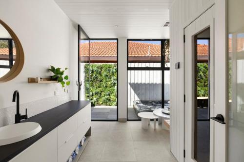 a bathroom with two sinks and a large window at Bayside Grandeur w Heated Pool,Spa,Sauna,5 Ensuites in Melbourne