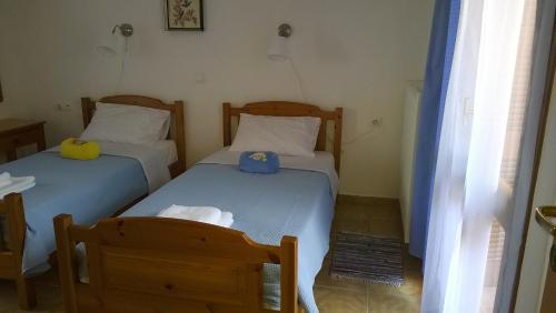 two twin beds in a room with two chairs at House of Polymnia in Sissi
