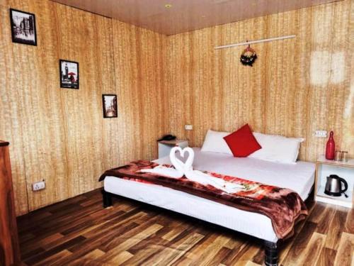 a bedroom with a bed with a white ribbon on it at Soma Caves in Kulu