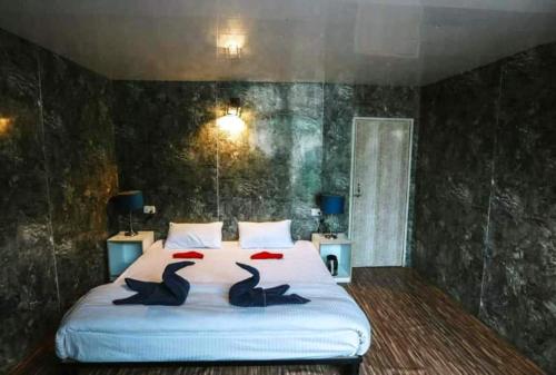a bedroom with a bed with two birds on it at Soma Caves in Kulu