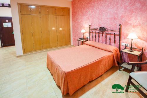 a bedroom with a bed and a dresser at Complejo Turístico Rural Nazaret De Moguer in Moguer
