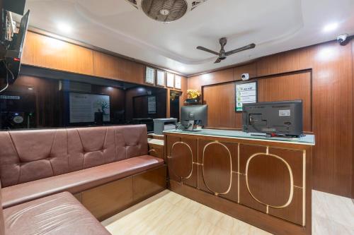 a waiting room with a bench and a tv at Treebo Marina Grand, Railway station in Visakhapatnam