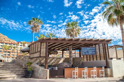 a kiosk at the beach with palm trees at Sandos Finisterra All Inclusive in Cabo San Lucas
